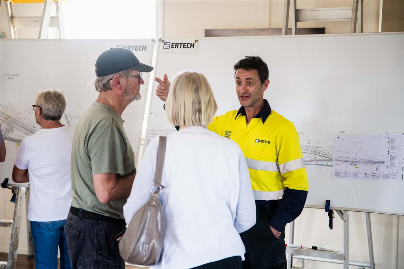 Residents discussing design plans with a project team member at a community information session